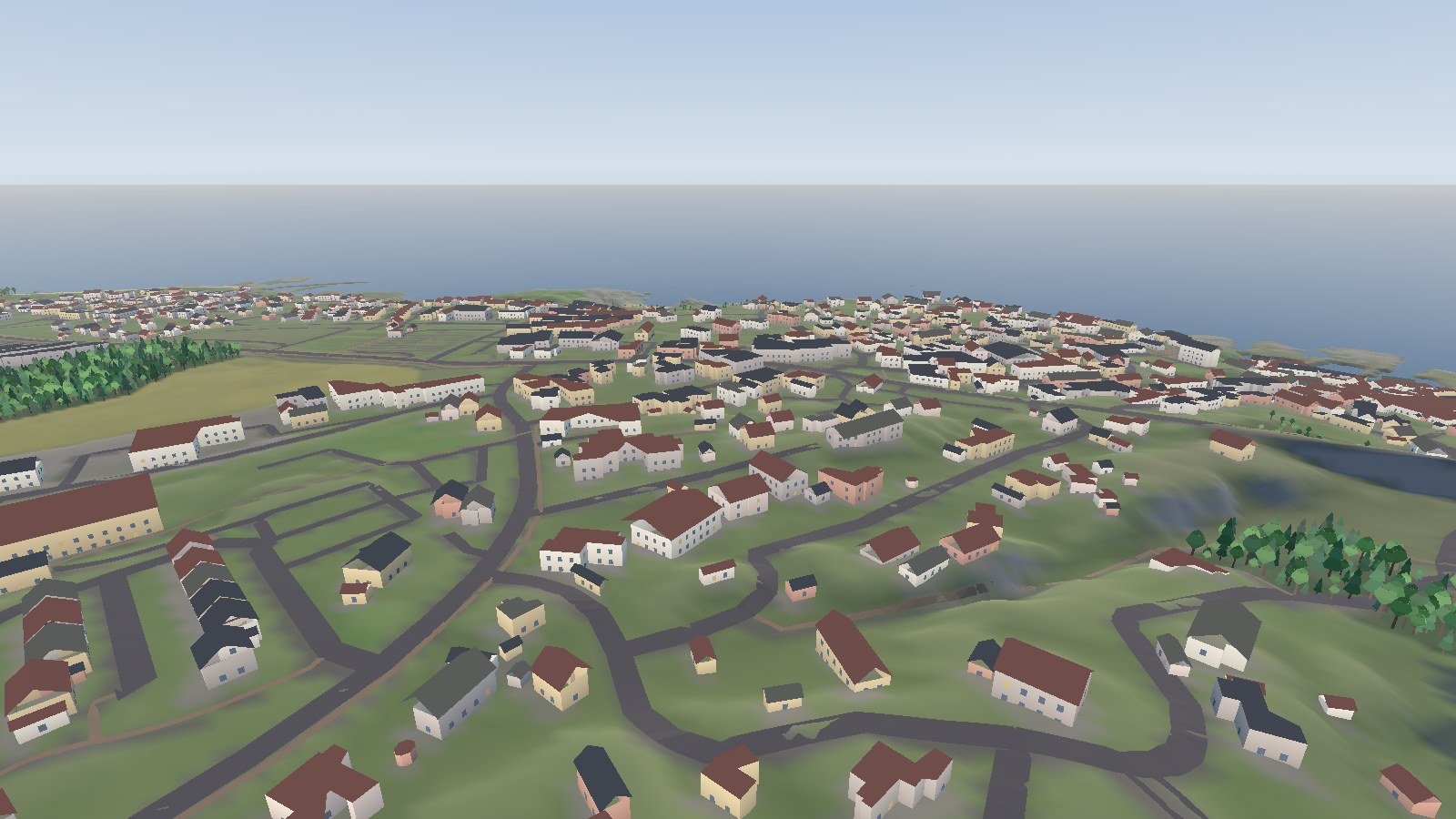 Gudhjem seen from the high ground west of it, the town spread along the coast below.